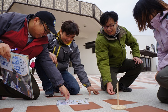 參與者手持簡易工具測量日照角度及風向， 尋覓園區最適合休憩及活動的地方 (台江國家公園管理處提供)