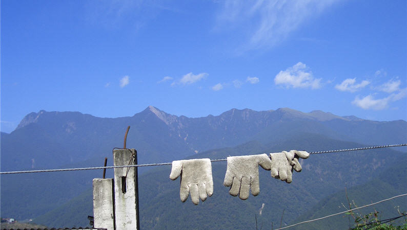 Although being sort of bizarre, the white gloves hung in front of the mountain landscape seem relaxing and interesting